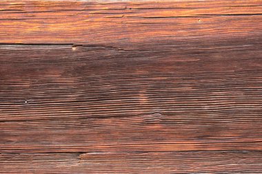 Macro shot of an ancient weathered dark brown cracked wood beam surface with nice rough grain texture.