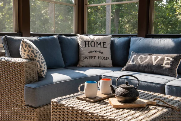 モダンなポーチの窓 パティオの家具 クッション 枕付きの屋外リビングスペースの居心地の良いコーナー コーヒーやティーポット コーヒーテーブルの上のカップ 背景の森 — ストック写真