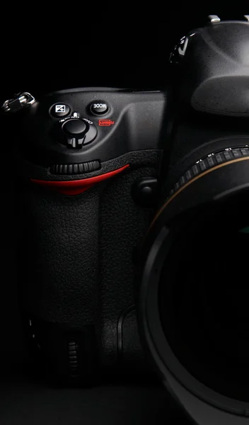 Профессиональная цифровая фотокамера на черном фоне — стоковое фото