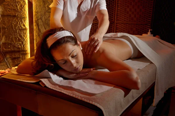 Gelukkig jonge vrouw tijdens massage sessie — Stockfoto