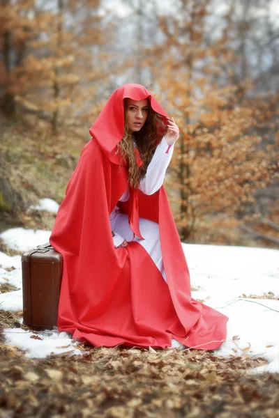 Mulher bonita com manto vermelho e mala — Fotografia de Stock