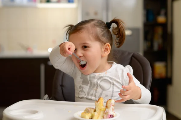 かわいい女の子のケーキを食べる — ストック写真