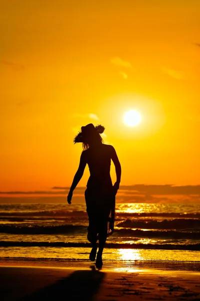 Silueta de mujer joven en la playa en verano — Foto de Stock