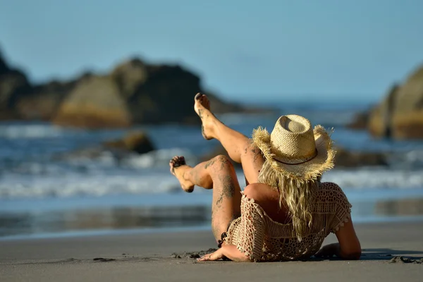 Young woman sitting on the beach — Stock Photo, Image