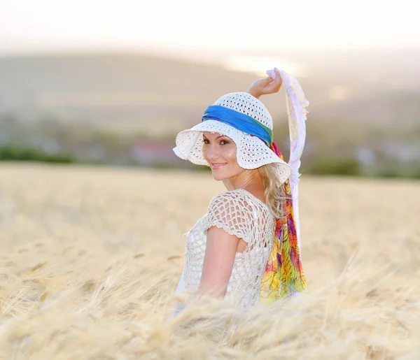 Молода красива жінка на золотому зерновому полі влітку — стокове фото