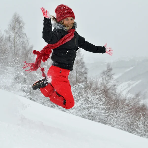 Молодая женщина на открытом воздухе зимой наслаждается снегом — стоковое фото