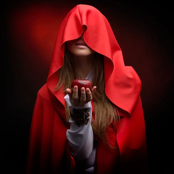 Beautiful woman with red cloak holding apple — Stock Photo, Image