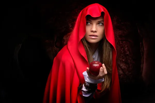 Красивая женщина с красным плащом и фруктами — стоковое фото
