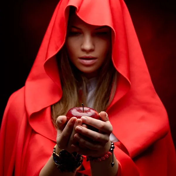 Bela mulher com manto vermelho segurando maçã — Fotografia de Stock