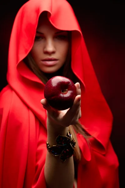 Beautiful woman with red cloak holding apple — Stock Photo, Image