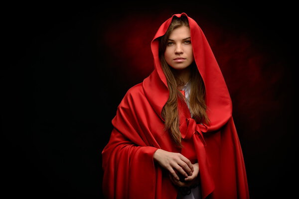 Beautiful woman with red cloak in studio