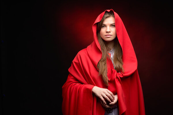 beautiful woman with red cloak in studio
