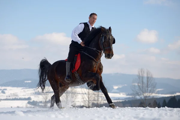 Young man riding horse outdoor in winter — Stock Photo, Image