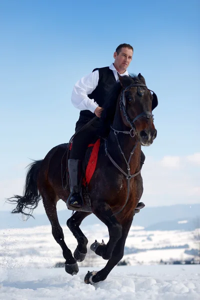 Giovane uomo a cavallo all'aperto in inverno — Foto Stock