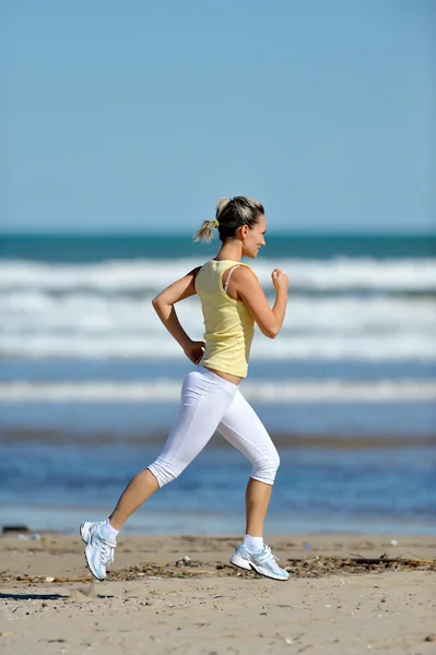 Mujer joven corriendo en la playa en verano — Foto de Stock