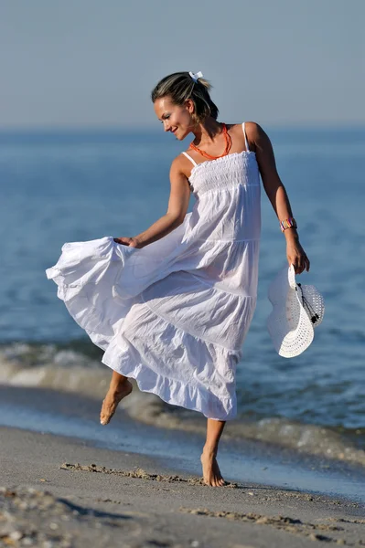 Jeune femme heureuse sur la plage en été — Photo