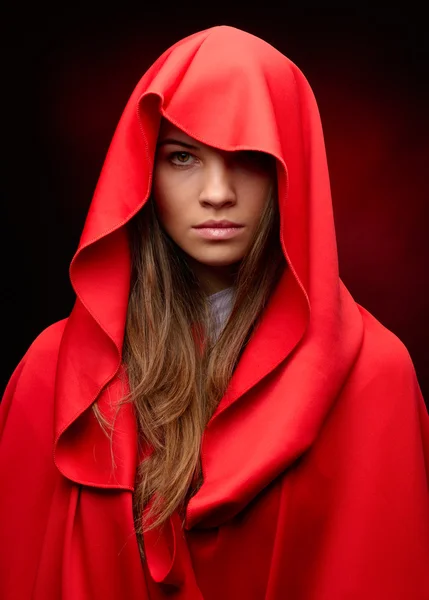 Beautiful woman with red cloak in studio — Stock Photo, Image