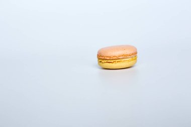 Beyaz arka planda makarun, beyaz arka planda bir badem kurabiyesi bulunur.