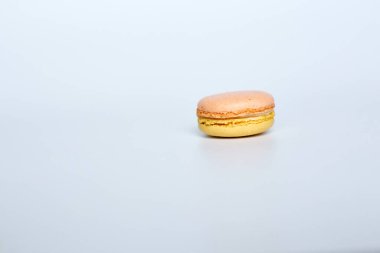 Beyaz arka planda makarun, beyaz arka planda bir badem kurabiyesi bulunur.