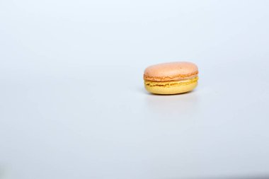 Beyaz arka planda makarun, beyaz arka planda bir badem kurabiyesi bulunur.