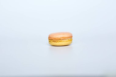 Beyaz arka planda makarun, beyaz arka planda bir badem kurabiyesi bulunur.