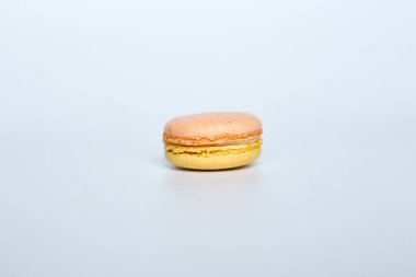 Beyaz arka planda makarun, beyaz arka planda bir badem kurabiyesi bulunur.