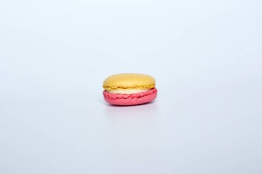 Beyaz arka planda makarun, beyaz arka planda bir badem kurabiyesi bulunur.