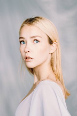 Taze makyajlı ve saç stili olan güzel bir genç kadın. Açık tenli açık renkli bir portre..