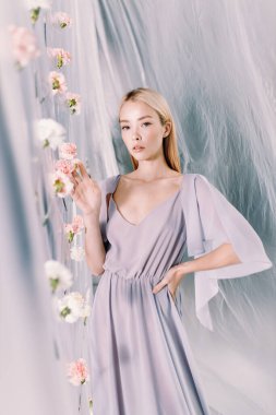 Beyaz ve pembe çiçekli güzel bir kadının portresi. Polietilen ile bahar moda fotoğrafçılığı.