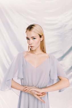 Arka planda çiçekler olan polietilen giymiş güzel bir kızın portresi. Moda portresi, çevre gündemi.