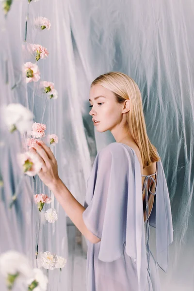 Porträt einer jungen schönen Frau mit weißen und rosa Blumen. Frühlingsmodefotografie mit Polyethylen. — Stockfoto