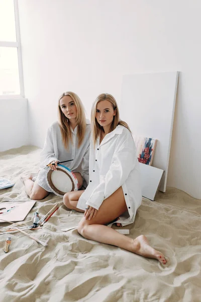 姐妹们在沙滩上的摄影棚里快乐双胞胎女孩的肖像 — 图库照片