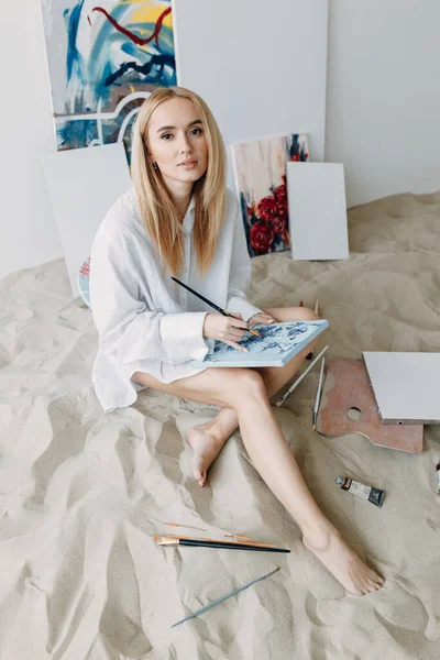 Ein Mädchen Sitzt Sand Einem Fotostudio Ein Junger Künstler Malt lizenzfreie Stockbilder