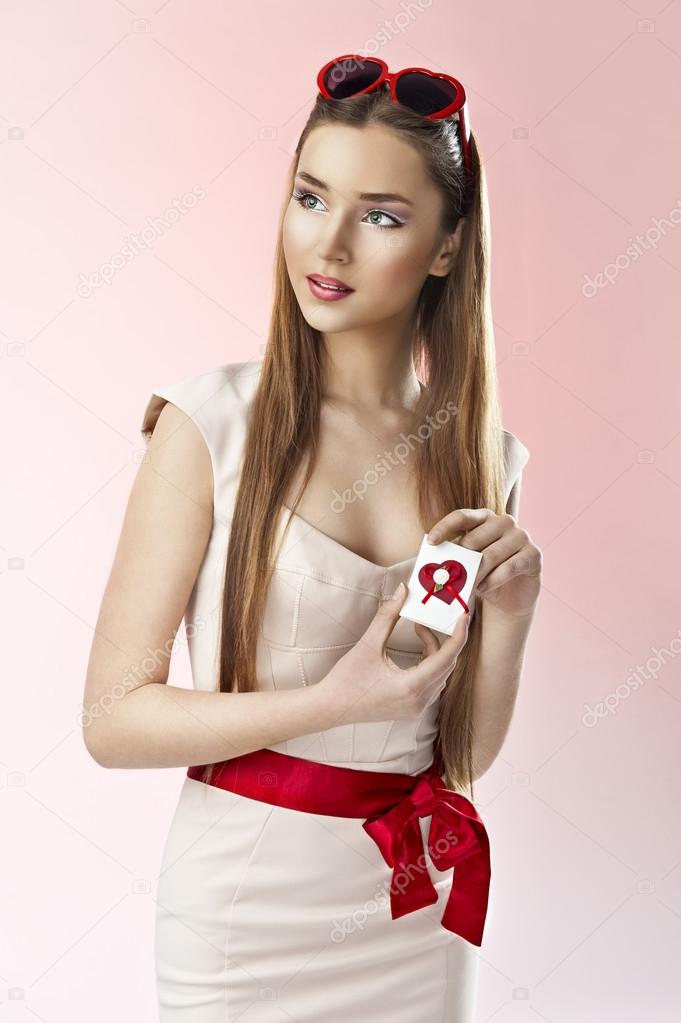 Valentine's day portrait of an attractive young brunette girl holding valentine's day card