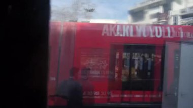 Şehir caddelerinde yürüyen insanların önünden geçmek Tramvay penceresinden sola sağa kaydırmak