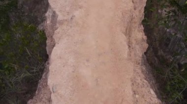 Walking Onto Rock Bridge Above Flora - Handheld And Slide Forward