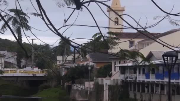 Kilise Ağaç Dalları Nın Arkasındaki Kaynağının Yakınındaki Diğer Kasaba Binaları — Stok video