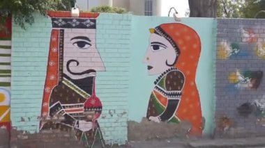 Duvarlardaki ve arabalardaki sokak grafiti sanatının yanından geçerken soldan sağa kayıyor.