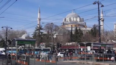 Cami önünde yürüyen ve elektrik hatları olan kalabalık tramvay istasyonu -
