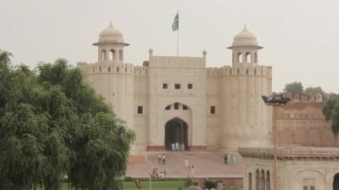 Building Frontage Behind Garden Tree Near People Walking - Static