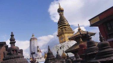 Birds Flying Near Statue Tops with Golden Temple Building In The Back - Handheld 