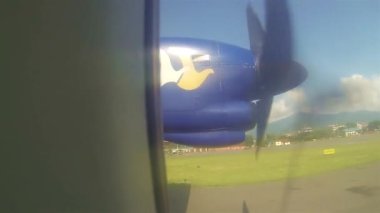 Kalkış sırasında pencere arkasında dönen uçak pervanesi soldan sağa kayıyor. 