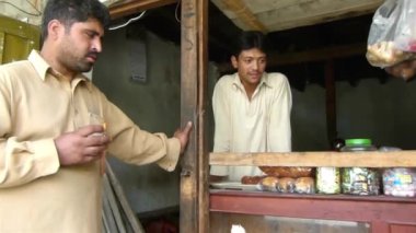 Men Talking To Old Man At Food Store Entrance - Pan - Left To Right