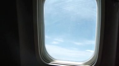 Man In Black Light In Front Of Blue View From Plane Window - Slide Forward