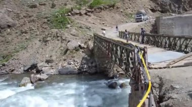 Car And People On Bridge Over River Water Source Flowing - Pan - Right To Left