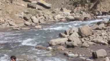 Man On Rocks Surrounding River Water Source Flowing - Static