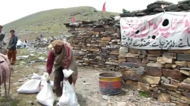 Men Near Old Rock House In Mountains - Pan - Left To Right 