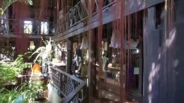 Woman Near Flora And Shop Behind Curtain Of Strings - Slide Forward