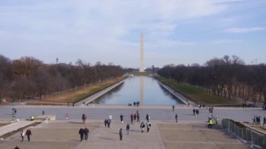 People Walking Down Stairs Near Water Source And Monument - Static