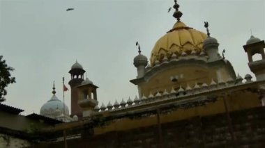 People Walking In Busy Street Near Mosque - Pan And Tilt - Up Right To Down Left